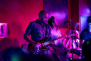 Musical group in concert, they play in a nightclub.