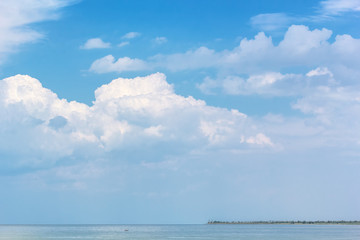 Obraz premium Picturesque seascape with white clouds above the sea