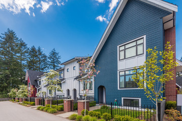 Fgrament of beautiful exterior of newly built luxury home. Yard with green grass and landscape.