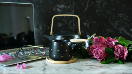 Feminine desk or workspace coffee break time with modern touch screen laptop on marble background.