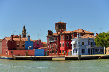 Fototapeta na wymiar Beautiful view of the canals of Burano from boat and beautiful, colorful buildings. Burano village is famous for its colorful houses. Venice, Italy.