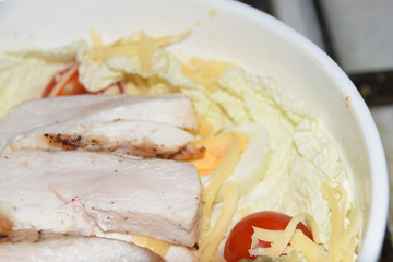 homemade caesar salad in large bowl abstract background chicken cheese tomatoes