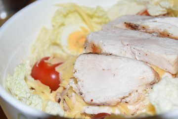 homemade caesar salad in large bowl abstract background chicken cheese tomatoes