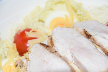 homemade caesar salad in large bowl abstract background chicken cheese tomatoes