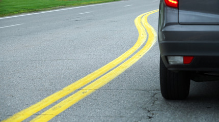 close up on car on the street with curved double yellow line