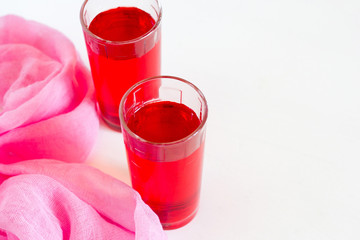 Fruit and berry red juice in glasses on a white background. Fresh and cold summer drink.