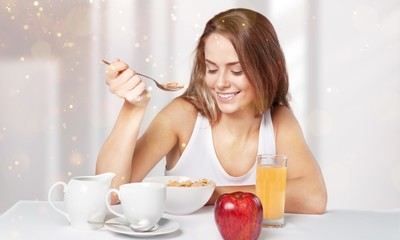 Obraz na płótnie Canvas Attracive young woman enjoying tea and fruits on breakfast