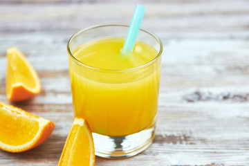 Fresh orange juice in a glass and orange slices on a shabby table light. horizontal view. detox. close-up. Copy space citrus refreshing drink.