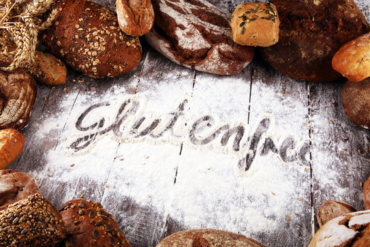 gluten free breads, glutenfree word written and bread rolls on wooden background