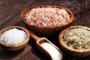 sea salt in bowl. Crystals of salt on table and himalayan salt.