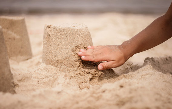 Kind baut eine Sandburg am Strand