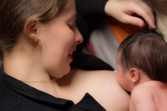 young woman breastfeeding her newborn baby