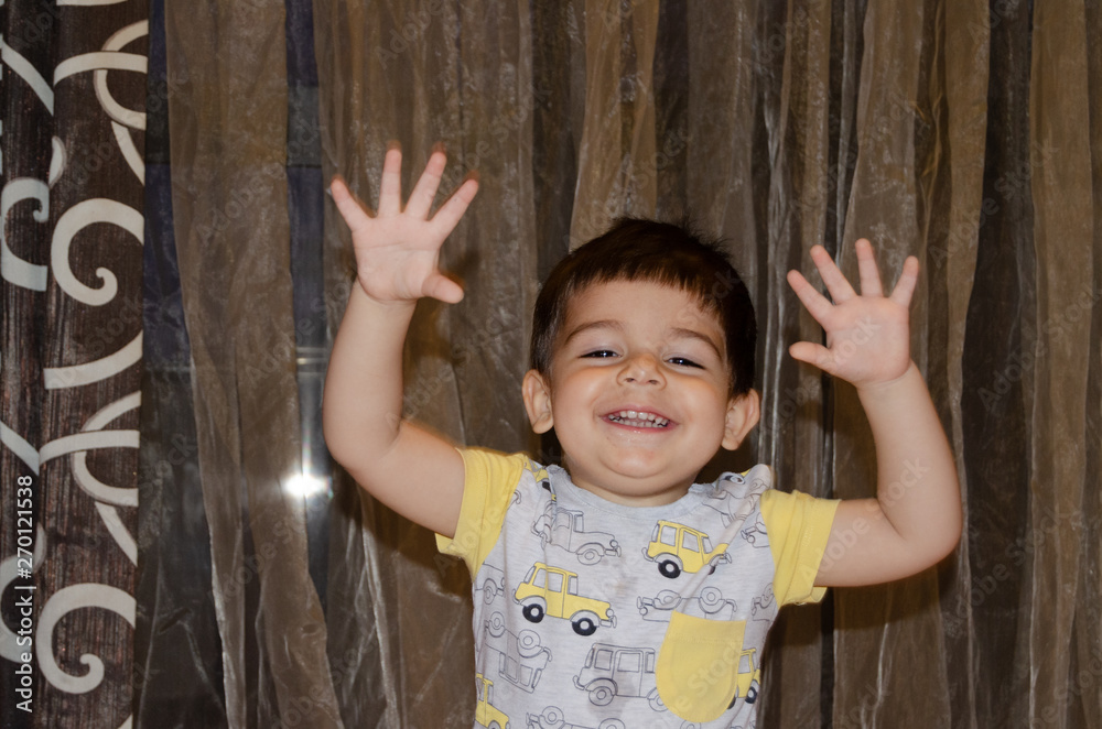 Wall mural cute two years old boy making funny faces early development concept, portrait, face expressions