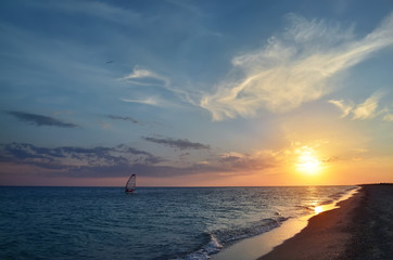 Windsurfing during sundown. A beautiful sunset with cirrus clouds over the Black Sea coast, Ukraine.