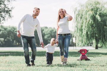 Obraz premium mother, father and play with their little son for a walk in the summer Park.