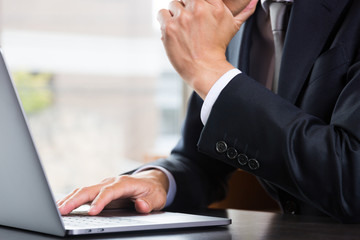 ノートパソコンを使うビジネスマン