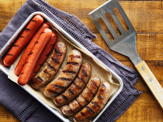 tray of grilled hot dogs and bratwursts on tray in top down composition