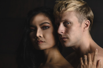 portrait of Caucasian male and Asian female having romance moment