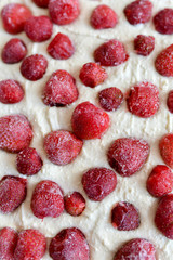 Strawberry pie before baking. Open cake with strawberries before baking. Located in a ceramic form on a blue background, top view.