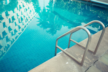 Grab bars ladder in the blue swimming pool