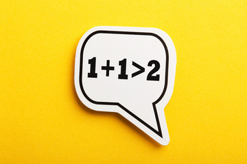 Synergy 1+1>2 Speech Bubble Isolated On Yellow Background