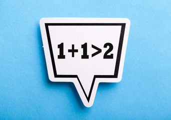 Synergy 1+1>2 Speech Bubble Isolated On Blue Background