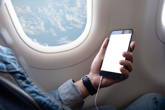 Asian man touching and slide mobile phone screen on airplane or aircraft,blank mobile phone screen mock up,selective focus
