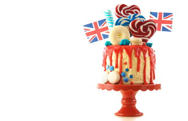 UK on-trend candyland fantasy drip cake with red, white and blue decorations, lollipops and flags...