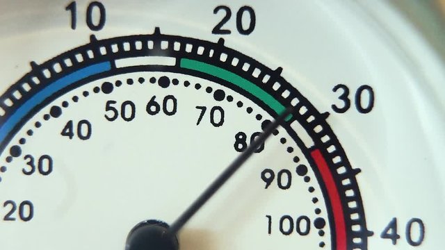 Macro close-up of thermometer quickly increasing from 76 deg F to 100 deg F (25 to 39 degrees C).