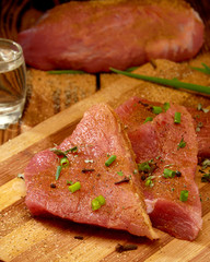 Fresh meat with herbs on a wooden Board cut into pieces and alcoho