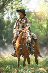 cowboy with his purebred horse standing in the forest