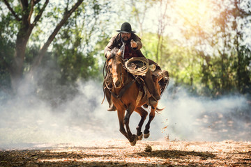 Cowboy riding a horse carrying a gun