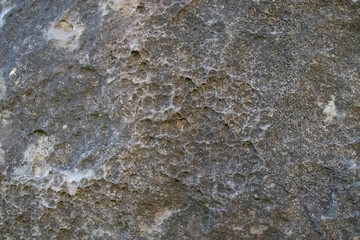 Close-up view of eroded rock with hole. Texture background. 