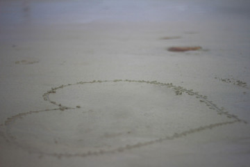 The shape of heart. Write on the sand of the sea. For write the name of sweetheart in Valentine's day, or for a wedding card. Blurred sea nutural background.