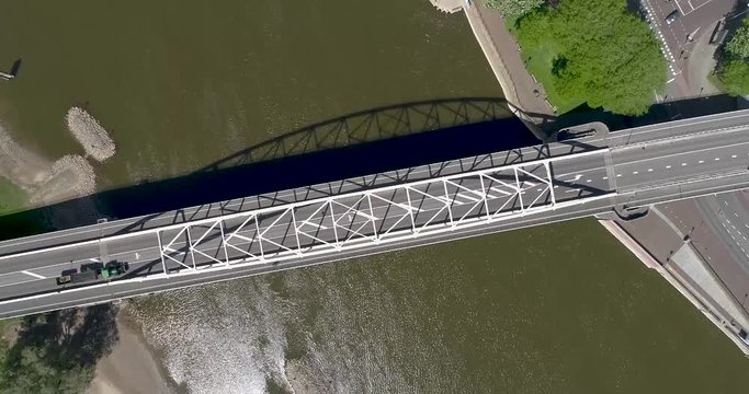 An 4k overhead rotating view of the Wilhelmina bridge in the old Dutch Hanza city Deventer above the river the IJssel showing passing traffic on a sunny day.