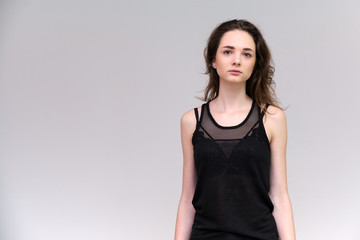 Obraz premium Life is a success. I am pleased with myself. Concept photo of a happy smiling woman satisfied life contented brunette girl in a black T-shirt and jeans on a gray background with flowing hair.