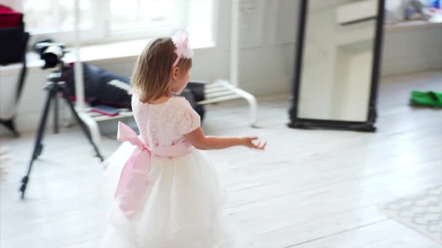 Cute little girl in beautiful white dress and headband at Christmas photo shoot