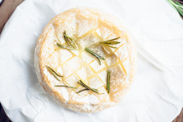 Baked camembert cheese with toasts and rosemary herbs on the rustc background. Selective focus. Shallow depth of field.