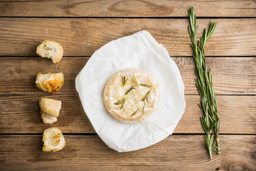 Baked camembert cheese with toasts and rosemary herbs on the rustc background. Selective focus. Shallow depth of field.