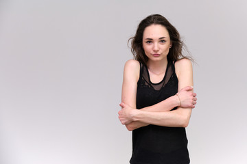 Life is a success. I am pleased with myself. Concept photo of a happy smiling woman satisfied life contented brunette girl in a black T-shirt and jeans on a gray background with flowing hair.