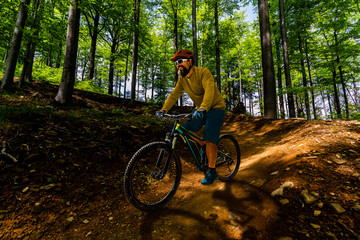 Fototapeta na wymiar Cycling man riding on bike in mountains forest landscape. Cycling MTB enduro flow trail track. Outdoor sport activity.