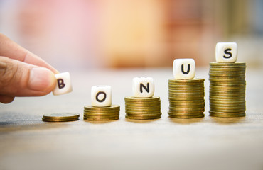 Yearly Bonus concept / hand holding words of bonus on stack coins staircase