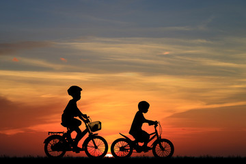 Fototapeta na wymiar Silhouette boy friend and bike relaxing on sunrise