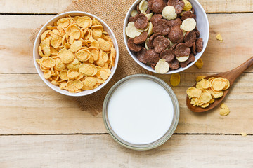 Breakfast Cornflakes and various cereals in bowl and milk cup on wooden background for cereal healthy food