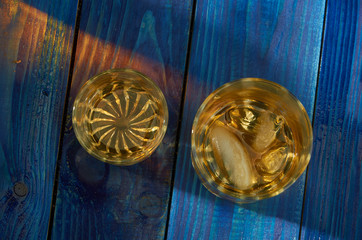 A glass of strong alcohol with ice in a transparent glass