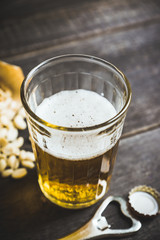 Glass of beer on the dark rustic wooden background. Selective focus. Shallow depth of field.