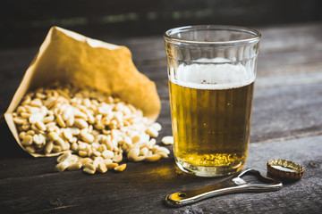 Glass of beer on the dark rustic wooden background. Selective focus. Shallow depth of field.