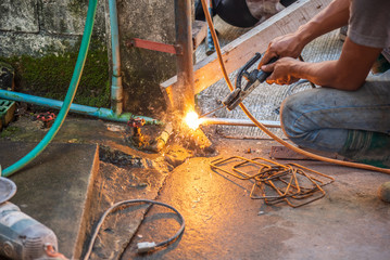 welder man fix the door with weld machine.