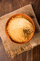 Organic Gur or Jggery Powder is unrefined sugar obtained from concentrated sugarcane juice. served in a bowl. selective focus