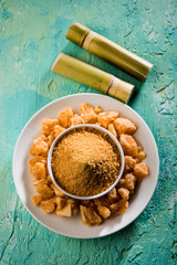 Organic Gur or Jggery Powder is unrefined sugar obtained from concentrated sugarcane juice. served in a bowl. selective focus